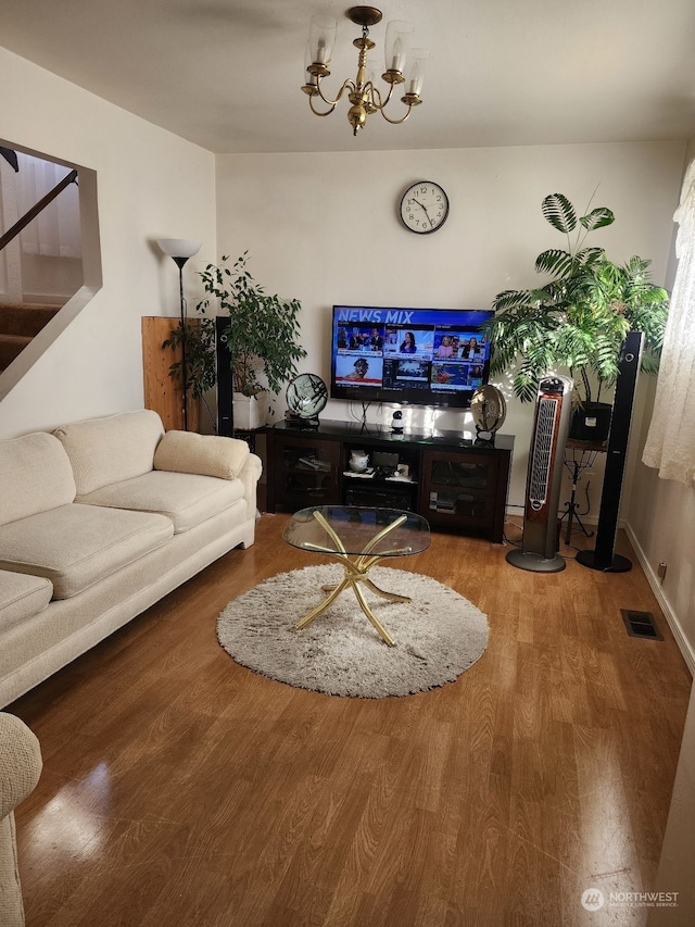 living room with a notable chandelier and hardwood / wood-style flooring