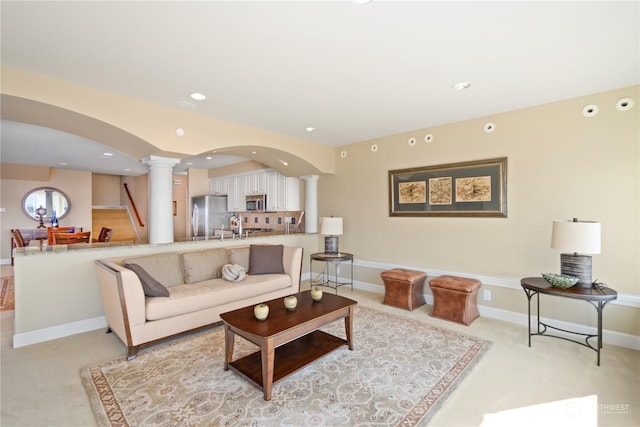 living room with decorative columns and light carpet