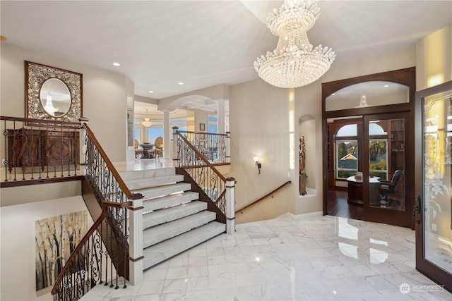 entryway with decorative columns, french doors, and a chandelier