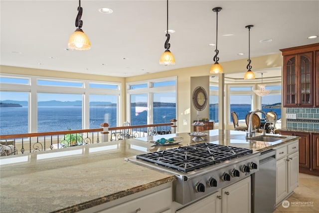 kitchen featuring appliances with stainless steel finishes, sink, a water and mountain view, and white cabinets