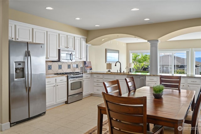 kitchen featuring light tile patterned flooring, sink, white cabinets, backsplash, and stainless steel appliances