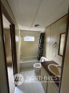 full bathroom featuring shower / tub combo with curtain, vanity, tile patterned floors, and toilet