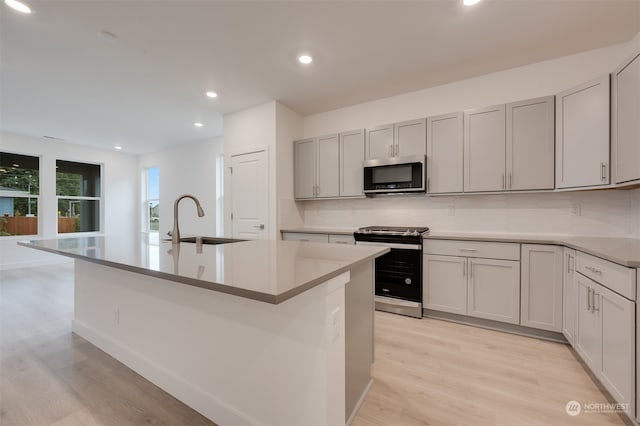 29209 217th Pl SE Unit 30, Black Diamond, WA 98010 - kitchen with a sink, tasteful backsplash, light wood-style flooring, and stainless steel appliances