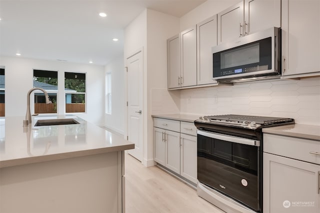 29209 217th Pl SE Unit 30, Black Diamond, WA 98010 - kitchen featuring a sink, light countertops, appliances with stainless steel finishes, and decorative backsplash