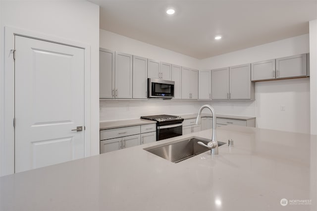 29209 217th Pl SE Unit 30, Black Diamond, WA 98010 - kitchen with gray cabinets, gas stove, stainless steel microwave, a sink, and light countertops