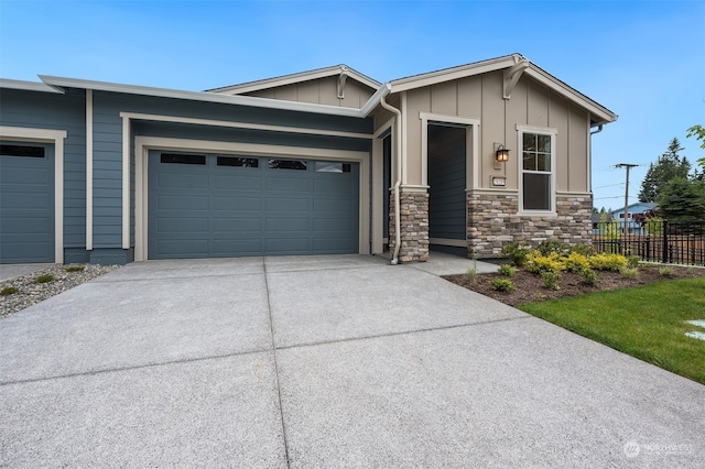 29209 217th Pl SE Unit 30, Black Diamond, WA 98010 - view of front of property featuring concrete driveway, stone siding, board and batten siding, an attached garage, and fence