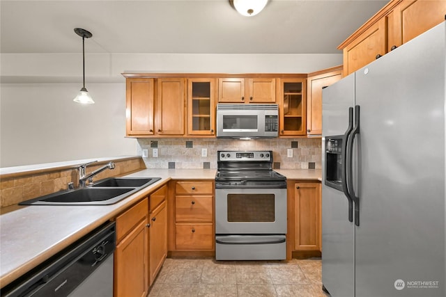 kitchen with stainless steel appliances, decorative light fixtures, sink, and decorative backsplash