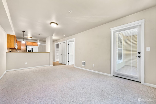 unfurnished living room featuring light carpet