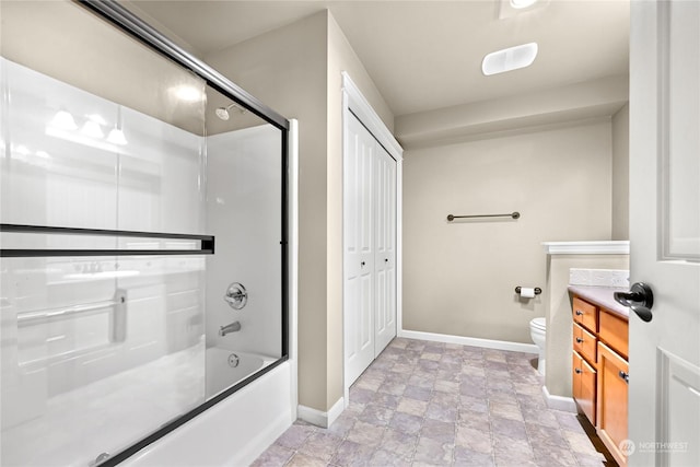 full bathroom with bath / shower combo with glass door, vanity, and toilet