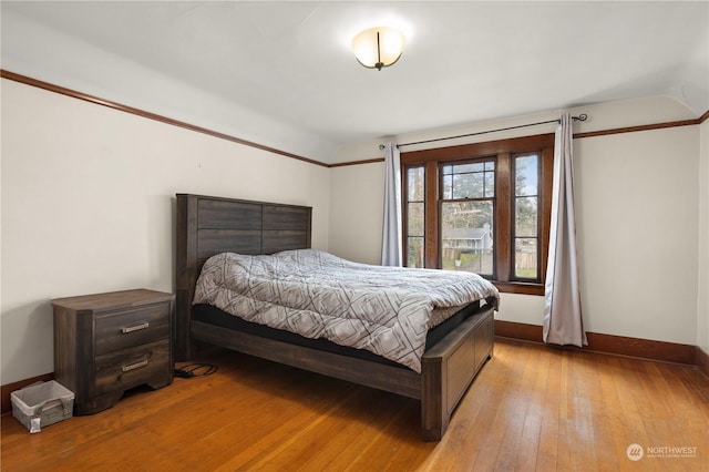 bedroom featuring lofted ceiling and light wood-type flooring