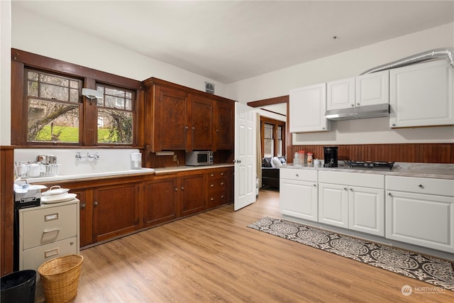 kitchen featuring black gas stovetop, light hardwood / wood-style flooring, and white cabinets