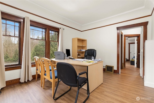 office space with ornamental molding and light hardwood / wood-style flooring