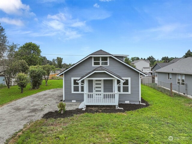 bungalow with a front lawn and covered porch