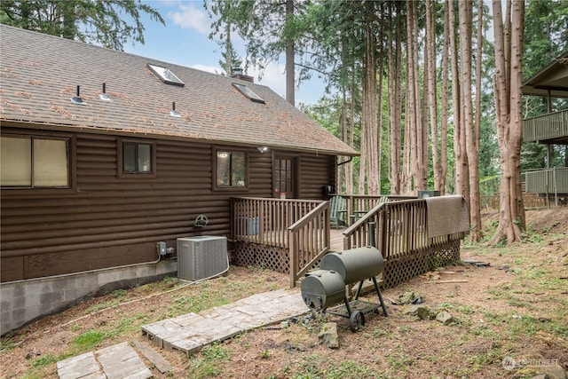 view of yard with central air condition unit and a wooden deck