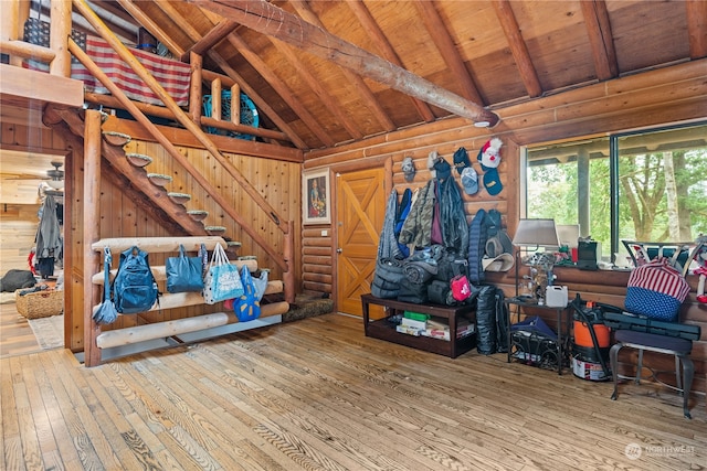 interior space featuring vaulted ceiling with beams, wooden walls, wooden ceiling, and light hardwood / wood-style flooring