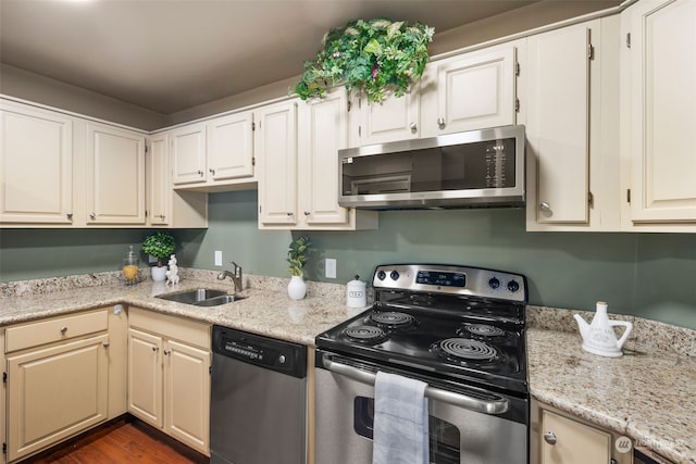 kitchen with sink, light stone counters, appliances with stainless steel finishes, dark hardwood / wood-style flooring, and white cabinets