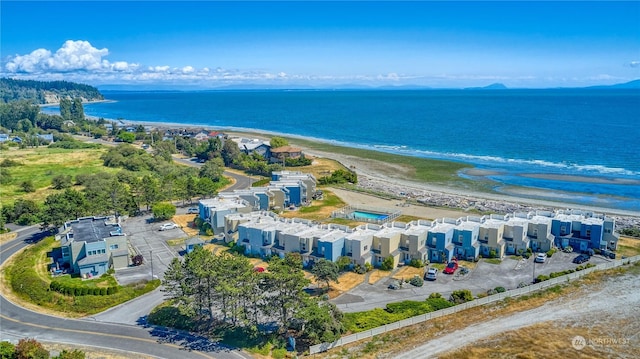 drone / aerial view featuring a water view, a residential view, and a view of the beach