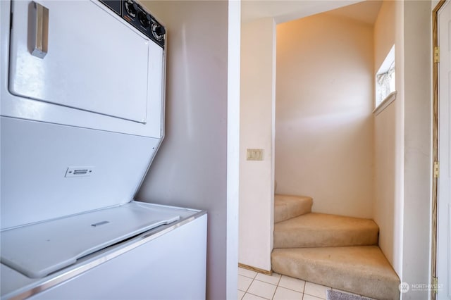 washroom featuring laundry area, light tile patterned floors, and stacked washer / dryer