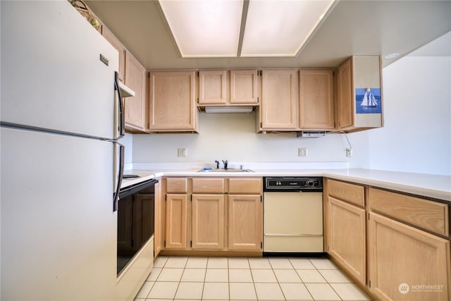 kitchen with electric range oven, light countertops, light brown cabinetry, and freestanding refrigerator