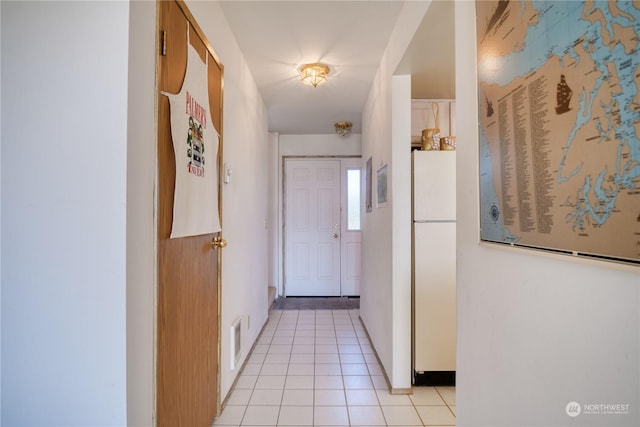 corridor featuring light tile patterned floors and visible vents