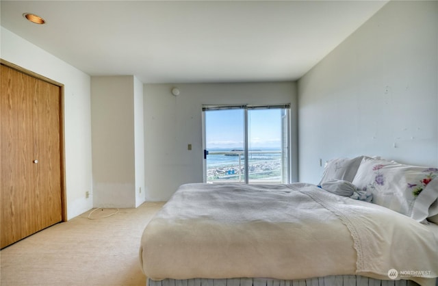 bedroom featuring light carpet and a water view