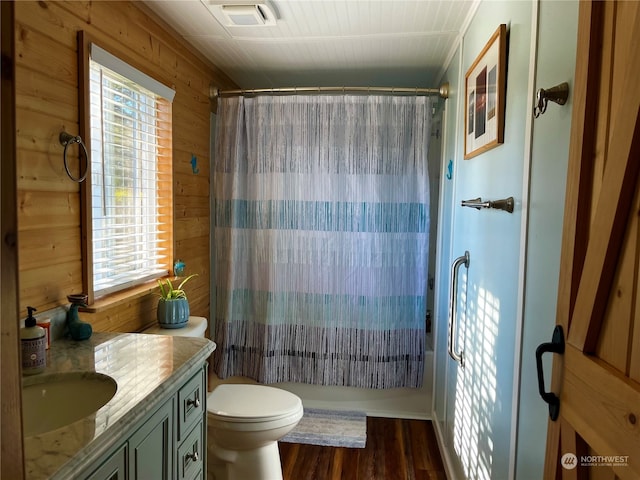 bathroom with hardwood / wood-style flooring, wooden walls, plenty of natural light, and toilet