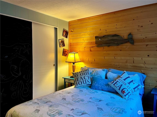 bedroom featuring wooden walls