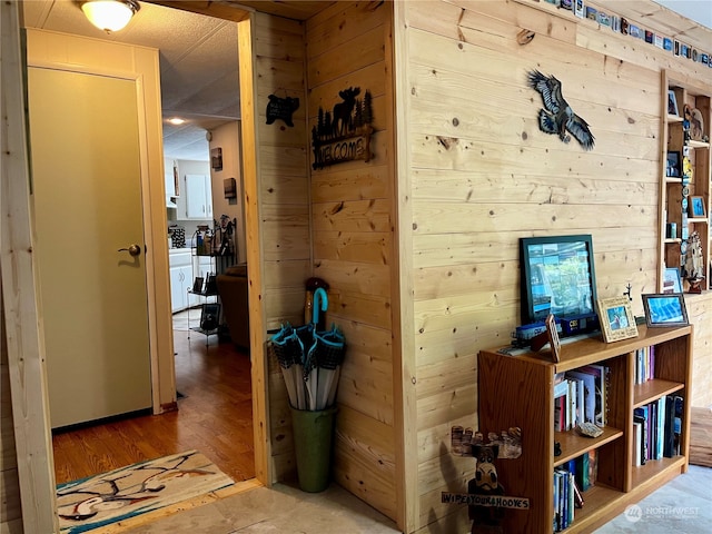 corridor with wood walls and hardwood / wood-style floors