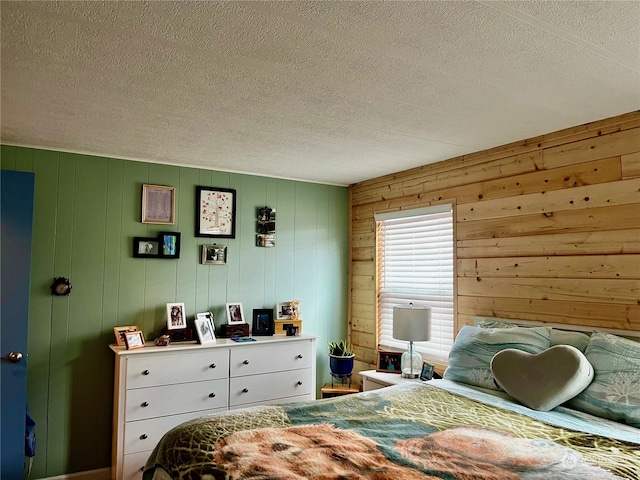 bedroom featuring a textured ceiling and wooden walls