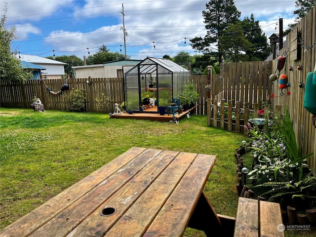 view of yard with a wooden deck and an outbuilding