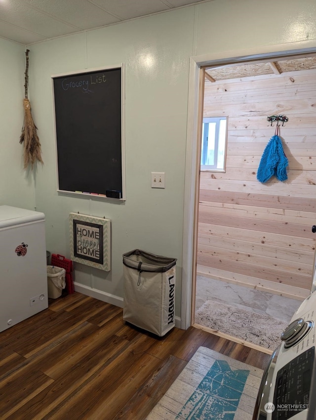 interior space with hardwood / wood-style floors and wooden walls