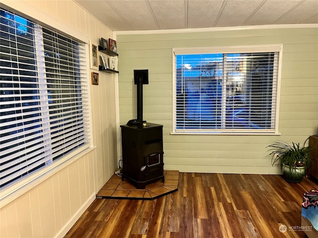 interior space featuring wooden walls, a wood stove, and wood-type flooring