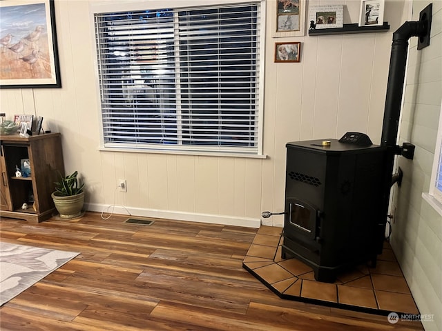 interior space with wood-type flooring and a wood stove