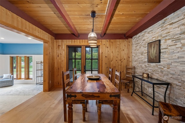 dining area with french doors, wood ceiling, light wood-type flooring, wooden walls, and beam ceiling