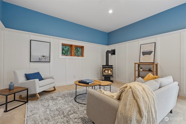 living room with light colored carpet and a wood stove