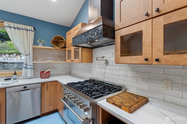 kitchen featuring lofted ceiling, backsplash, stainless steel appliances, light stone counters, and custom exhaust hood