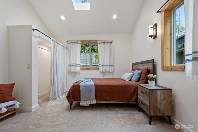 carpeted bedroom featuring lofted ceiling with skylight