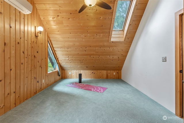 additional living space featuring carpet floors, lofted ceiling with skylight, a wall mounted AC, and wood walls