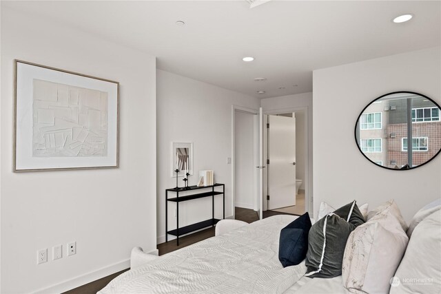 bedroom featuring dark hardwood / wood-style flooring and connected bathroom