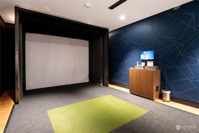 home theater room featuring carpet, golf simulator, and tile walls