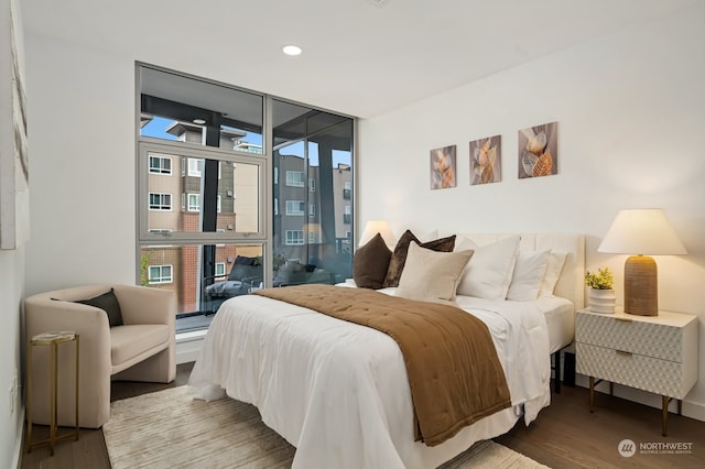 bedroom with hardwood / wood-style floors, access to outside, and floor to ceiling windows