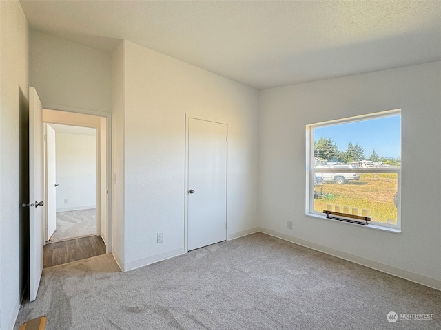 unfurnished bedroom with a closet and light colored carpet