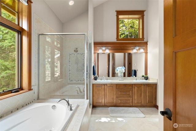 bathroom featuring a sink, vaulted ceiling, a bath, double vanity, and a stall shower