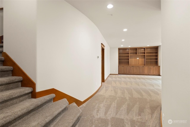 corridor with stairs, light carpet, baseboards, and recessed lighting