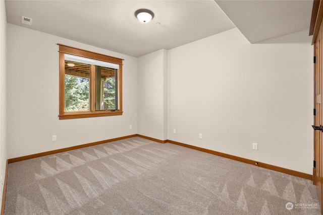 carpeted spare room with visible vents and baseboards