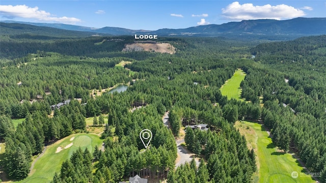 aerial view featuring view of golf course, a mountain view, and a forest view