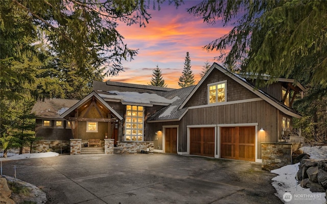 view of front facade with driveway and stone siding