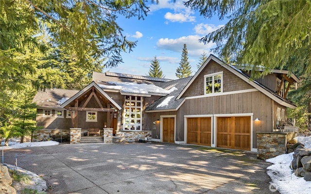 view of front facade with a garage, concrete driveway, and stone siding