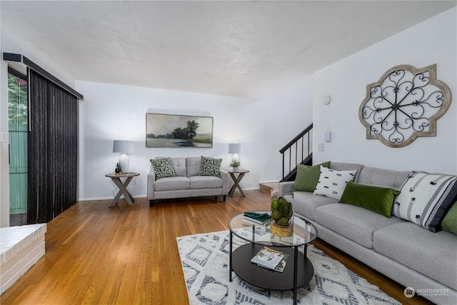 living room featuring wood-type flooring and a textured ceiling