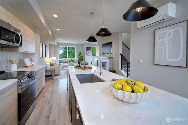 kitchen featuring appliances with stainless steel finishes, sink, decorative backsplash, hanging light fixtures, and a wall unit AC